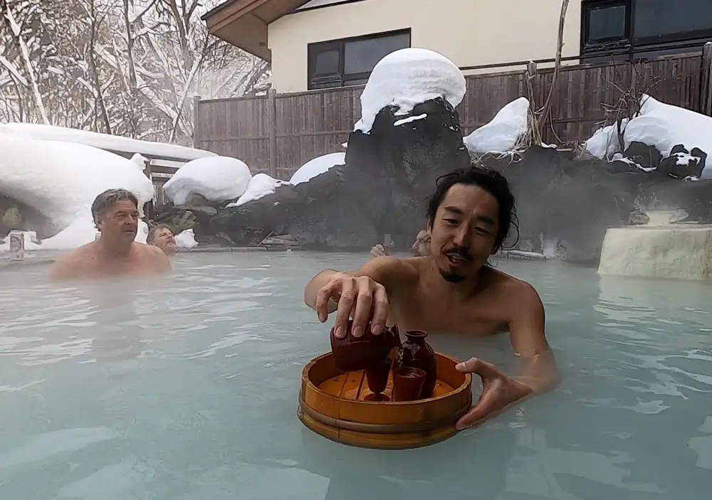 Our tail guide Taro pouring a sake in a Hachimantai onsen