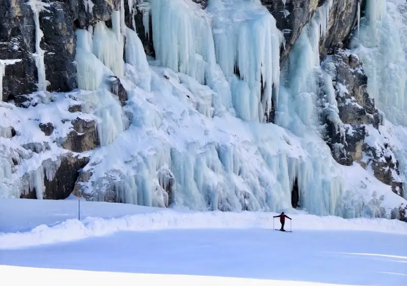 Scenic Dolomites Ski Safari at frozen waterfall in Hidden Valley